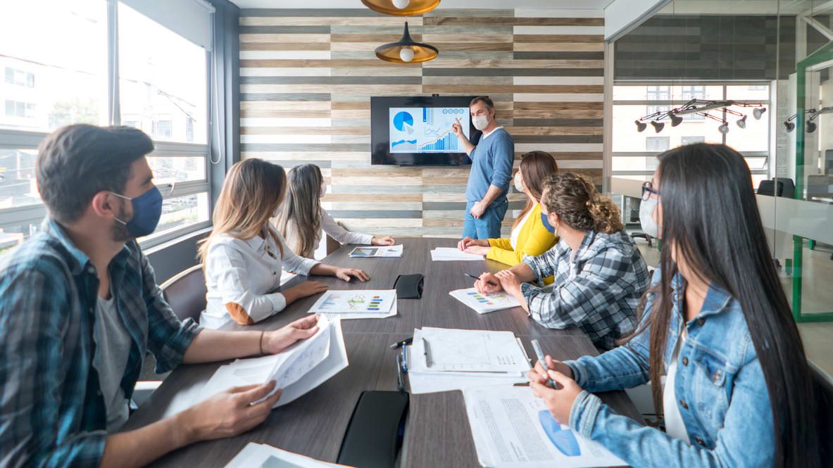 A group of people sitting around a table in a conference room.