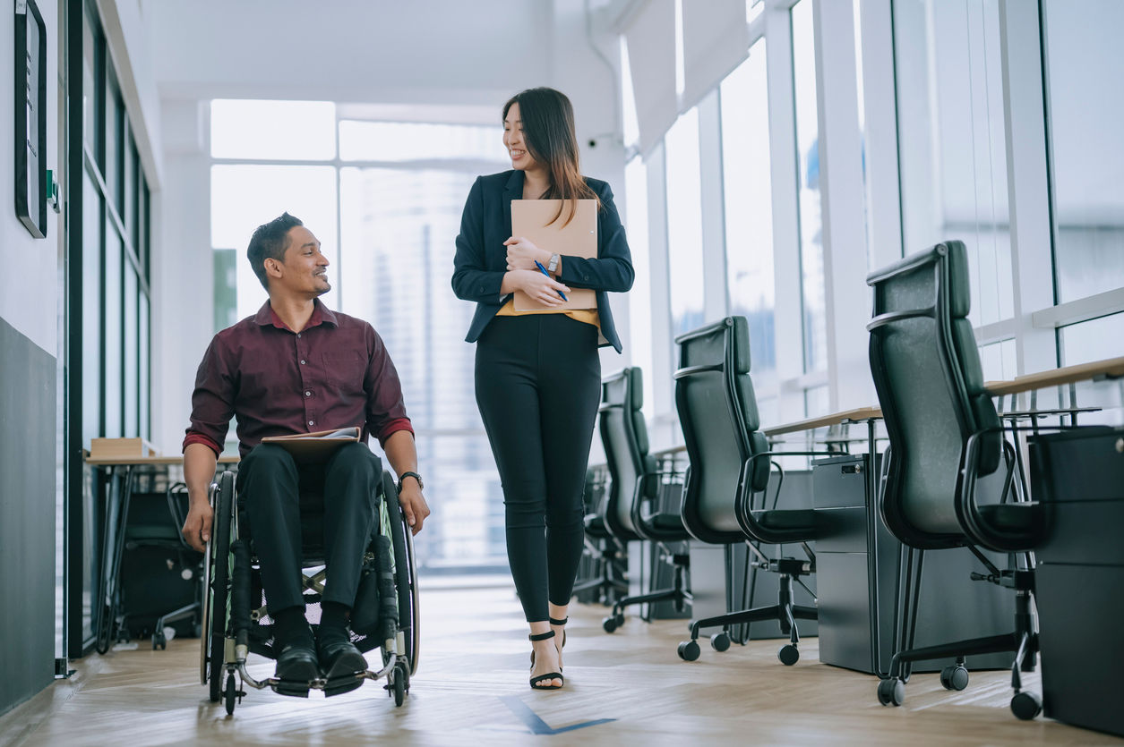 woman walking with man in wheelchair