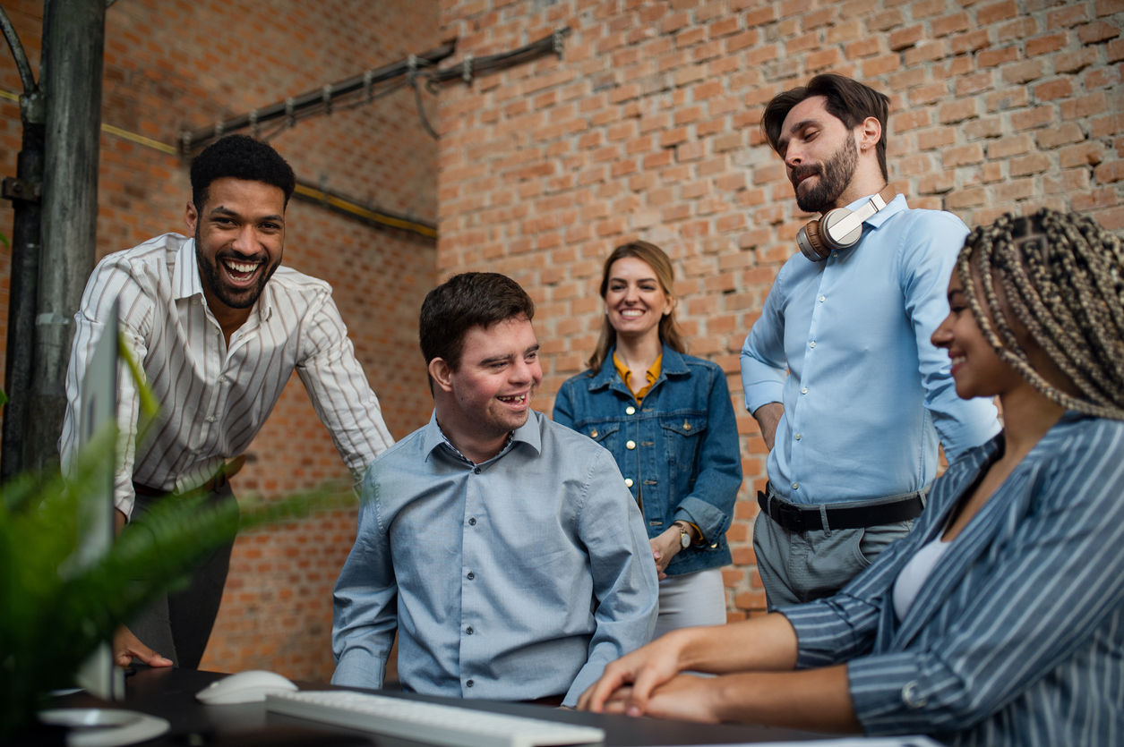 Diverse workers smile at each other