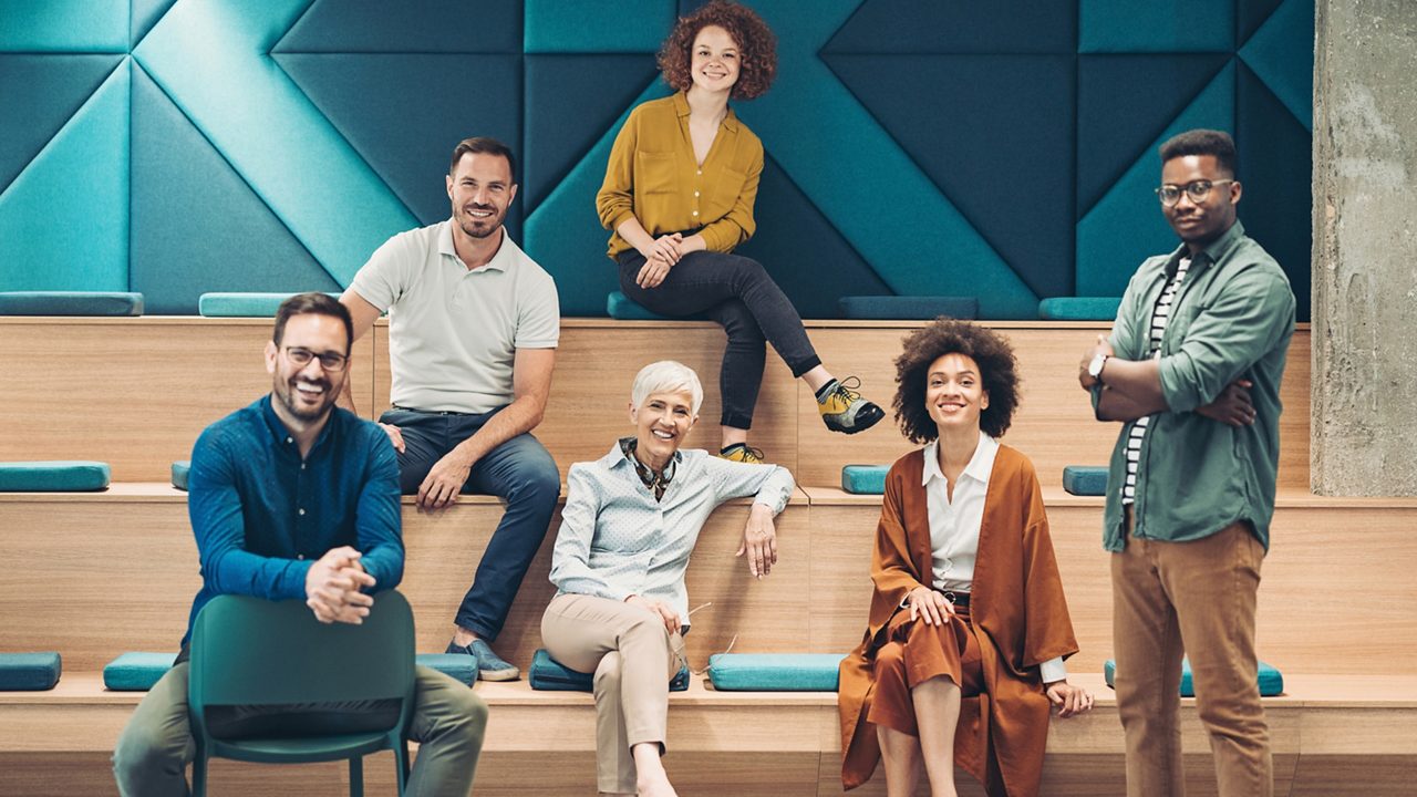 group of people sitting on staggered bench seating in a modern office