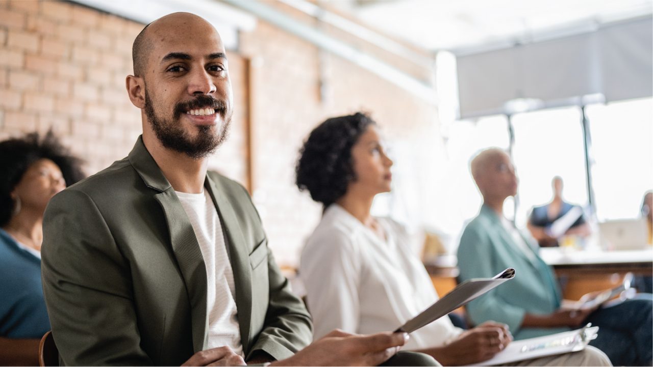 Team member in a meeting smiles at the camera