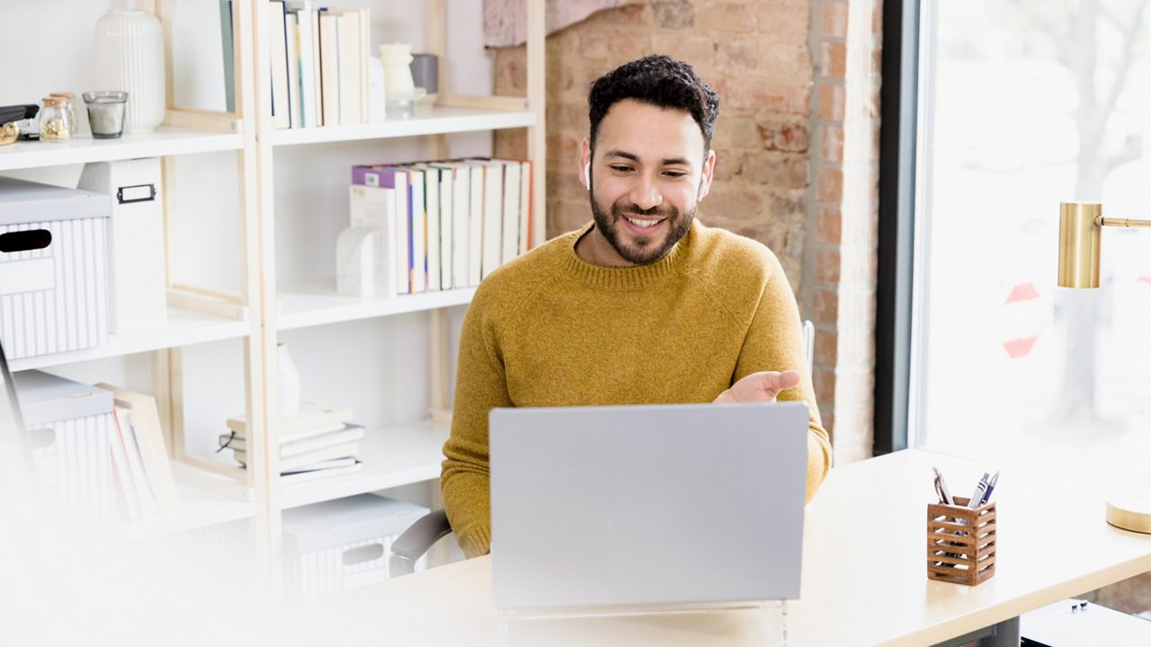 Employee smiles while in a virtual meeting.