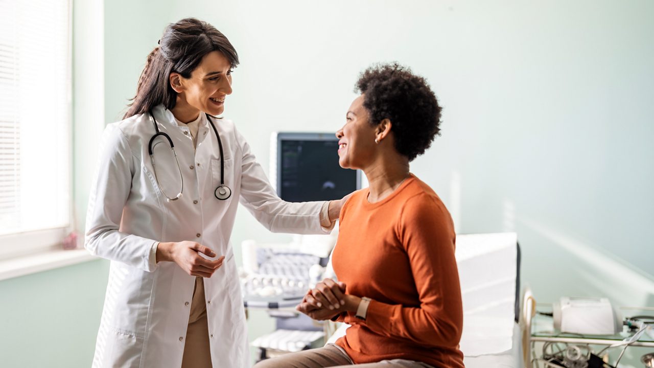 doctor assists female patient in a hospital room