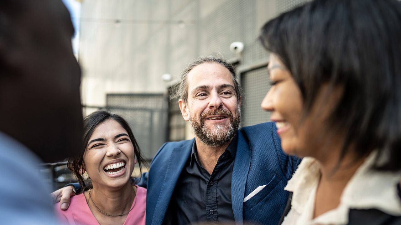 group of men and women laughing