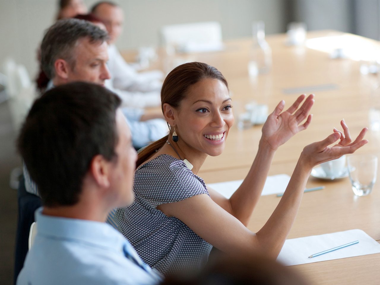 Woman smiles while speaking during a meeting.