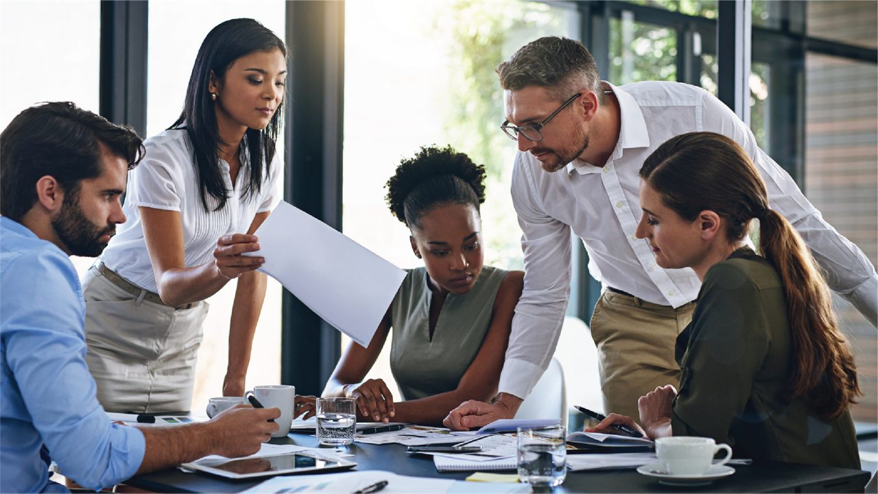 Employees sharing documents during a meeting.