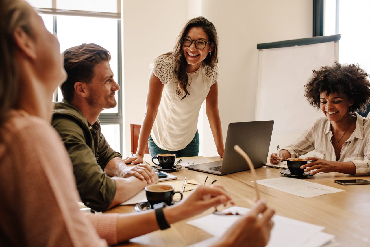 businesswoman smiling while in a meeting with coworkers