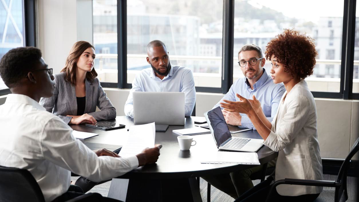 a diverse group of colleagues meet around a conference table