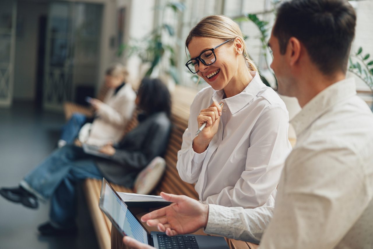 Woman office worker discussing new project with colleague during working day in coworking