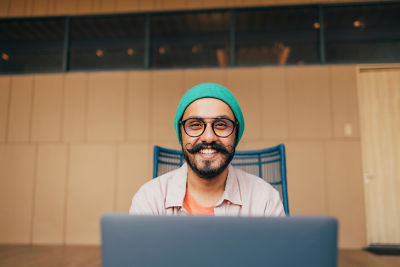 Click image of man with moustache in front of laptop in conference room smiling to navigate to page: Careers Opens in new window