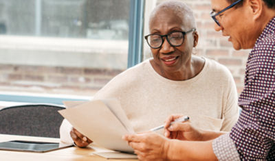 A woman and man sitting at a table discussing the creation of a personal trust.