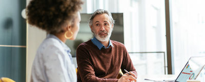 A man and woman next to a laptop discussing estate asset management.