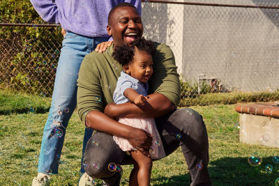 Father holding his child while thinking about future financial security and saving for retirement.