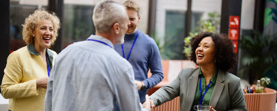 Woman leads meeting with seated colleagues.
