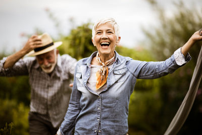 Joyful senior couple enjoying retirement outdoors, illustrating TIAA's retirement planning success