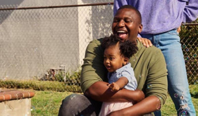 A dad and his young dauther sit outside