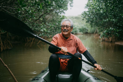 A man in a canoe paddling down a calm stream