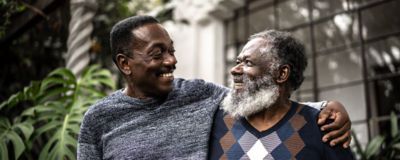 A father and son smiling in a warm embrace