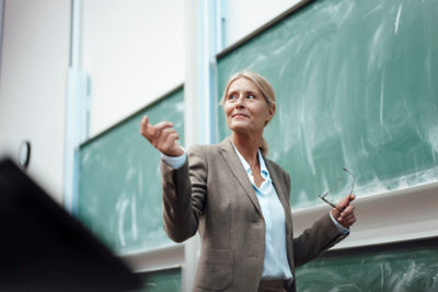 female teacher standing in front of chalk board