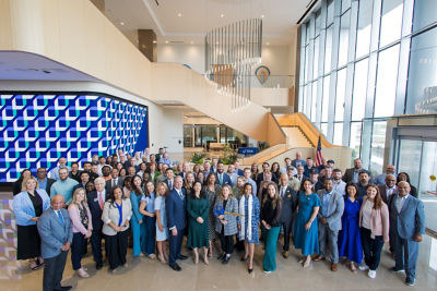 Several associates gathered in the spacious and soaring glass lobby of TIAA's new corporate center in Frisco, Texas.