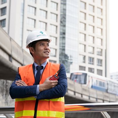 Man in a hard hat stands in front of a TIAA alternative investment project.