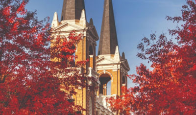 Higher education building surrounded by red fall leaves.