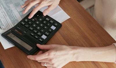 hand using a calculator on a table