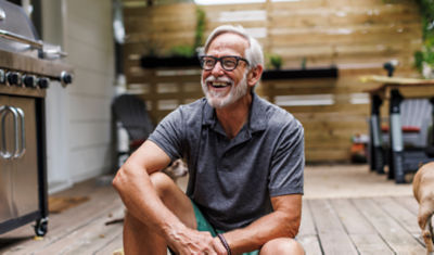 A man sitting on a porch smiling.