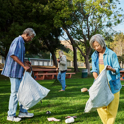 man and woman picking up trash