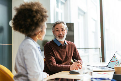 Woman and man sitting at table, conveying warmth and financial confidence