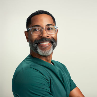 A middle-aged man standing with his arms folded.