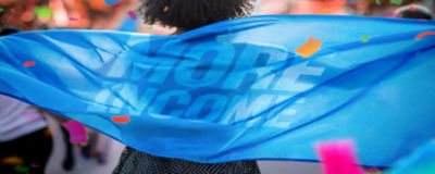 woman holding blue banner that says More income