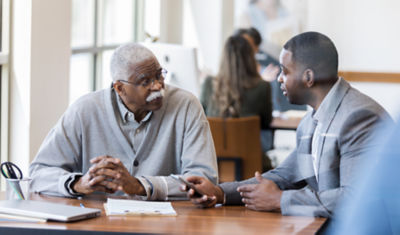 Older man and woman discussing estate planning with a woman in a suit.