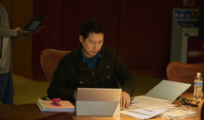Person reviewing financial documents and paperwork at desk with laptop - managing estate affairs and financial responsibilities during bereavement