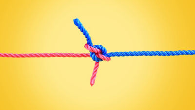 Pink and blue rope tied in a knot during tug-o-war.