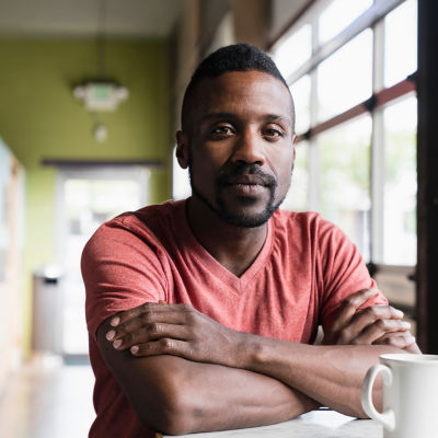 A man sitting in a café, having a cup of coffee.