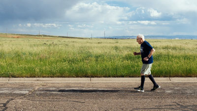 Click image of Elderly man exercising with an open prairie as the backdrop Opens in new window