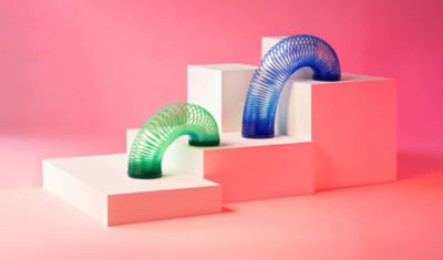 Slinky toys climbing the steps of a bar chart represent the flexible thinking health care and higher ed employers are using in order to grow.