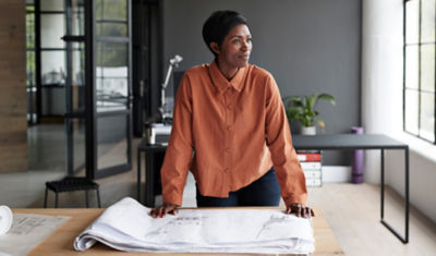 Woman reviewing personal financial plan and investments at table by window