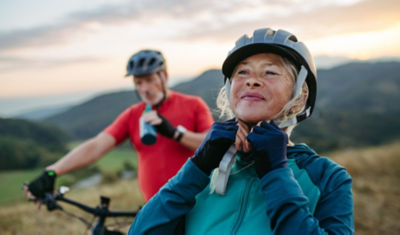 Active couple in their 50s biking outdoors while planning for retirement income and legacy