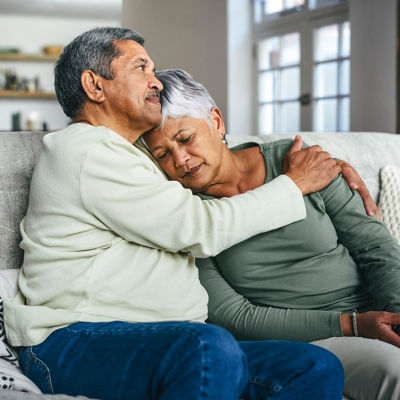 A woman in mourning is comforted by a man. 