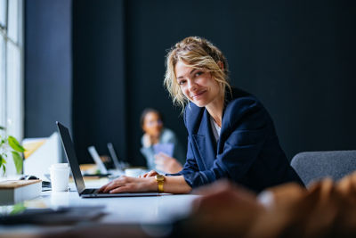 Woman sitting at a laptop smiling