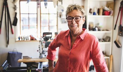 A woman in a red shrit standing in a sunny room.