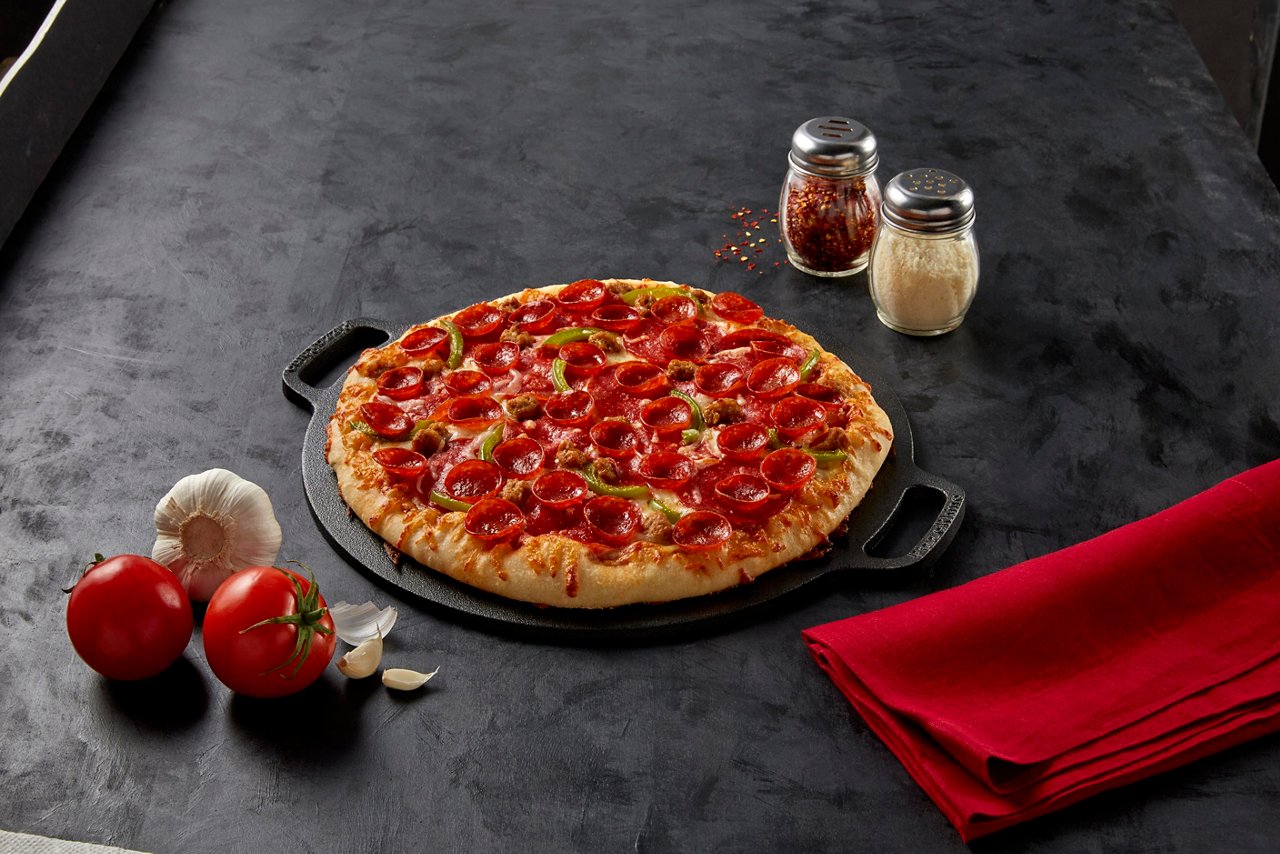 Image of meaty trio pizza on a skillet tray.