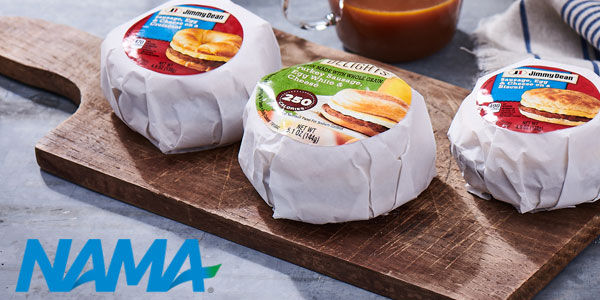 Three Individually wrapped breakfast sandwiches on a wooden cutting board