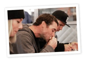 Man eating sandwich with gray hoodie 