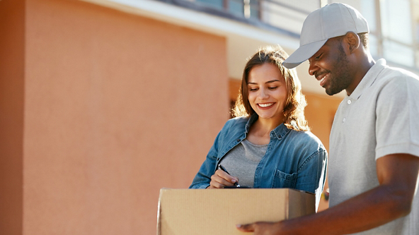 Male holding a package as a female signs for it 