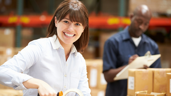 Female smiling at the camera as she tapes up a box 