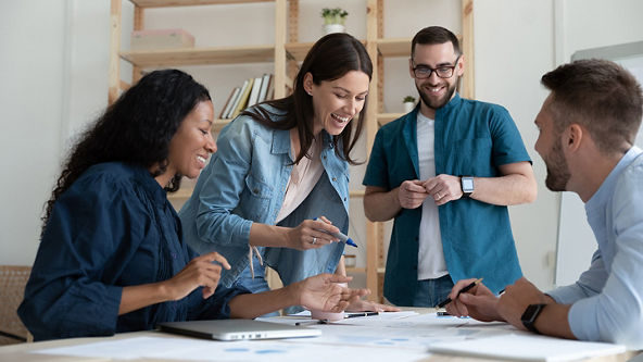 Group of people looking at papers and working together in an office
