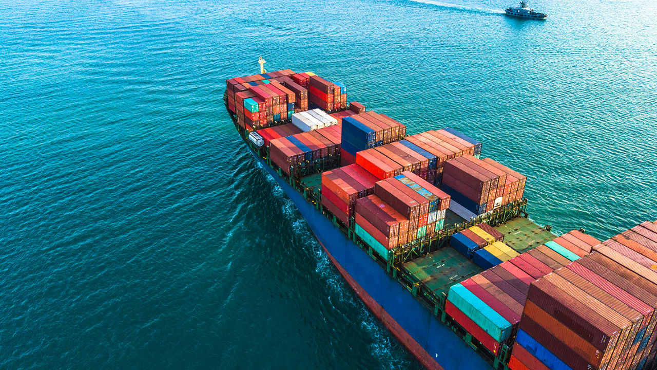 Cargo ship full of shipping containers going through turquoise water